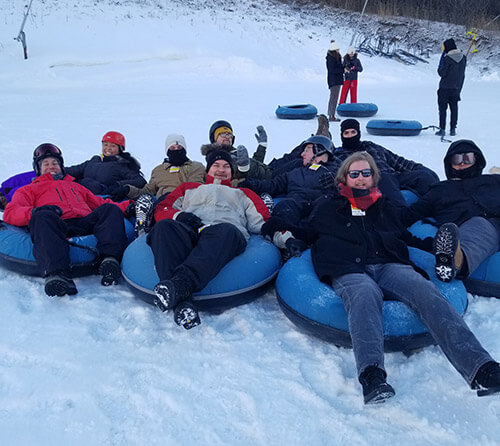 REM team in snow-tubes group photo